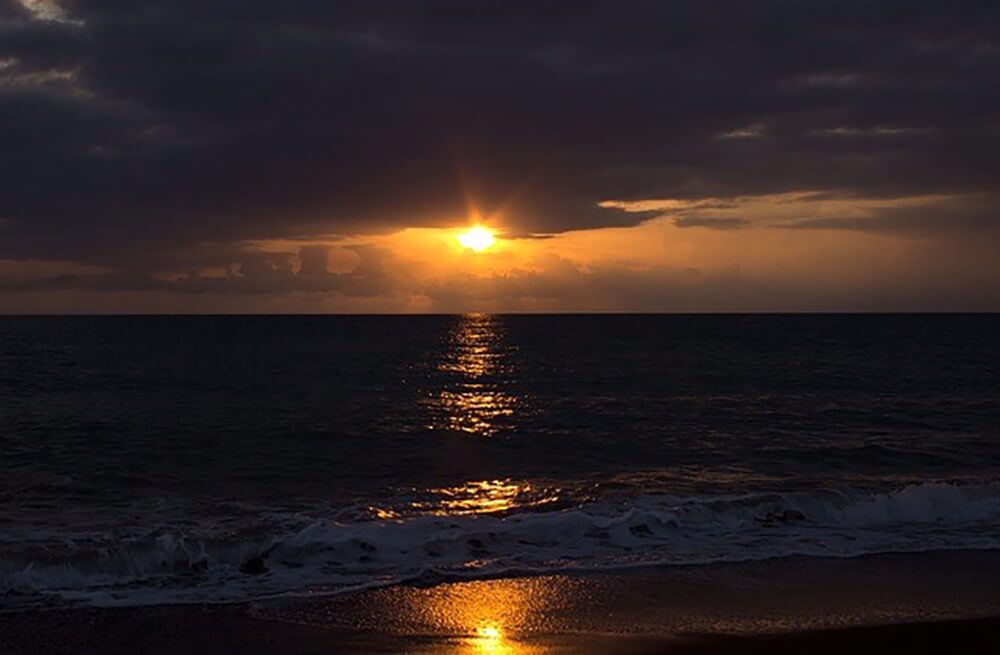夕日が沈むイタリアの海辺の風景