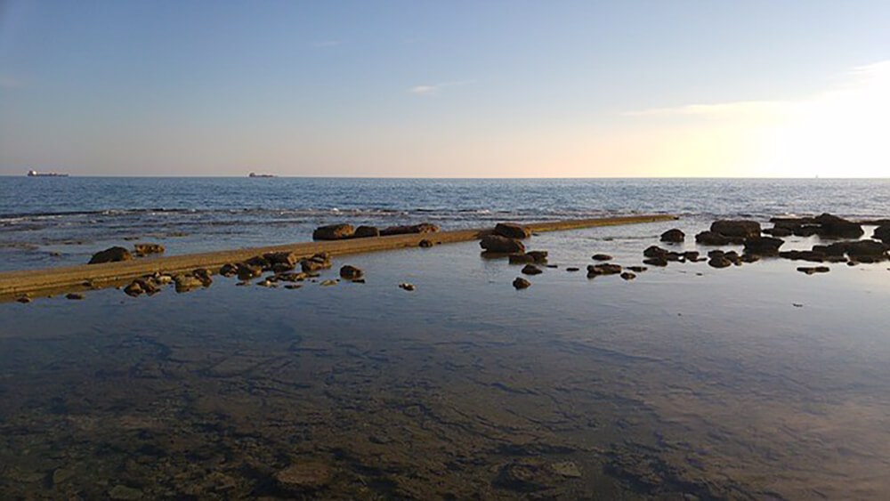 夕暮れの岩場が点在するリヴォルノの海岸沿いの風景