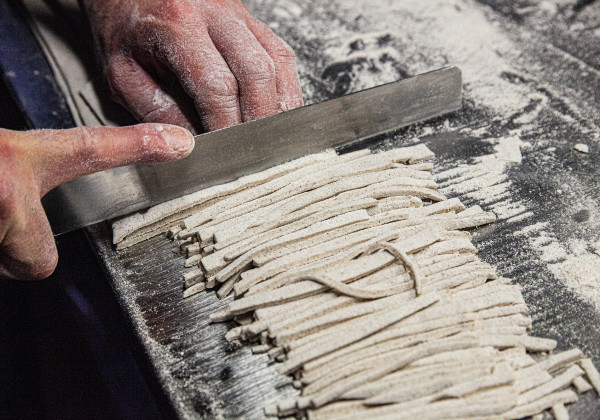 手作業でそば粉のパスタ「ピッツォッケリ」を切っている様子